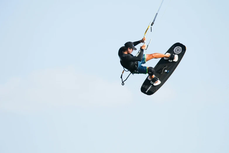 a man in the air holding onto a parachute