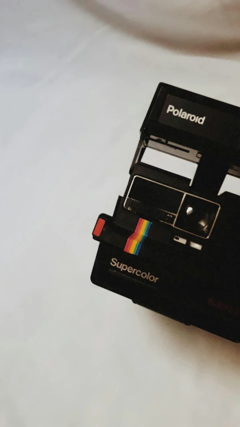 a polaroid camera on a white surface with the top opened