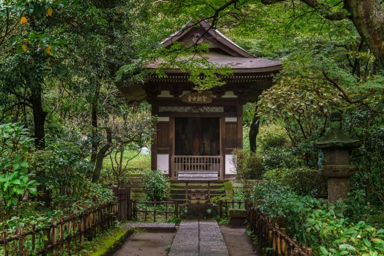 a small structure is surrounded by lots of green trees