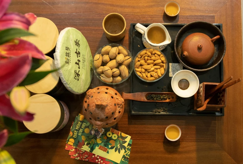 an assortment of teas, saucers and nuts are on a table