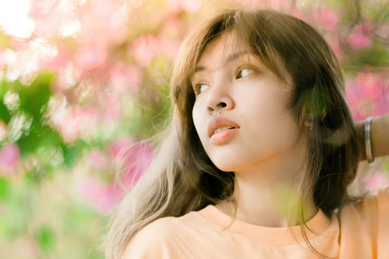 an asian woman standing in front of a tree with long hair