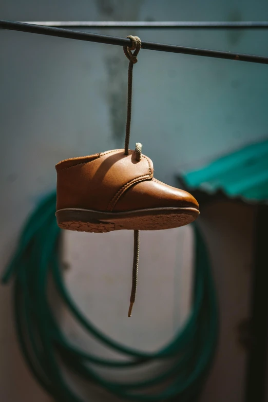 a pair of leather boots hanging on a wire