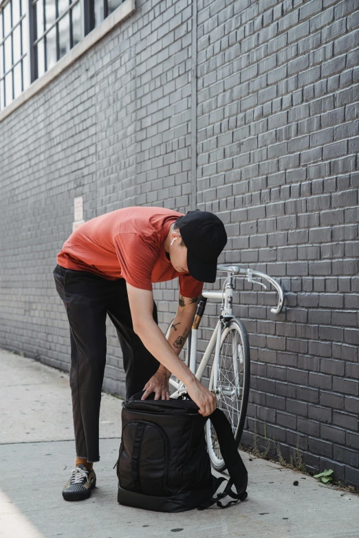 man bending over putting a bicycle in a suitcase