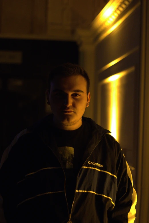 a man standing in a doorway at night with dark lighting