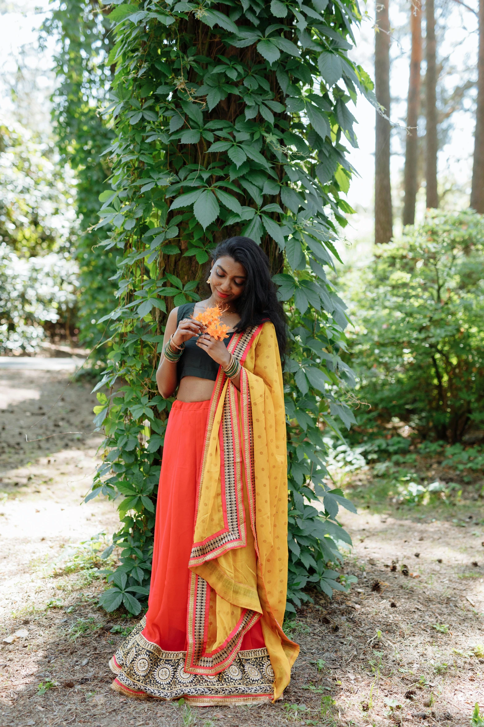 a woman is standing next to a tree with a flower