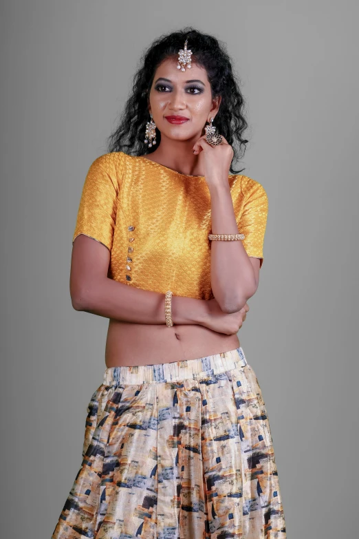 woman posing in yellow shirt and colorful printed skirt
