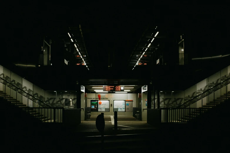 a man stands in the dark and opens the doors of his building