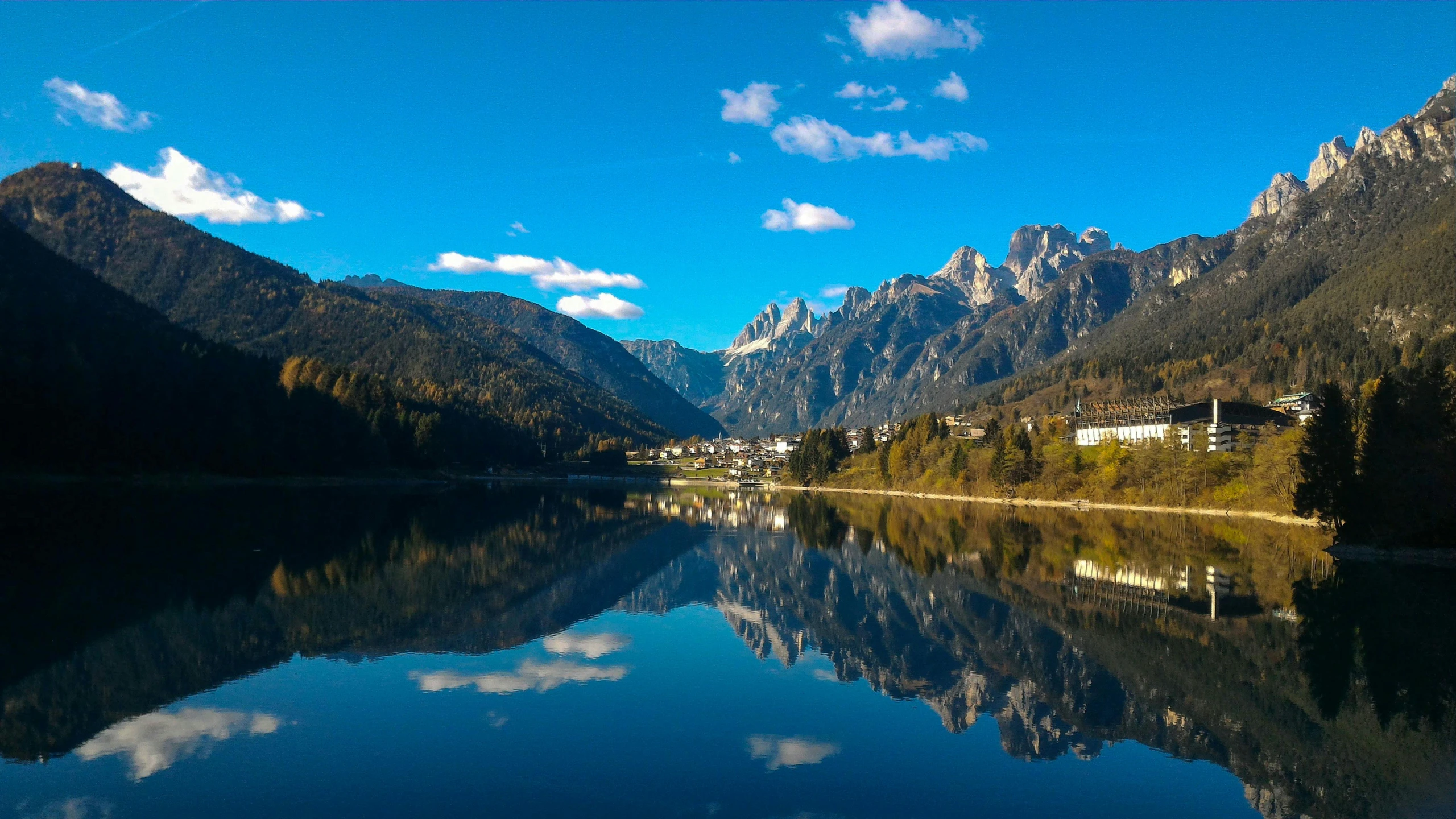 the mountain range is reflected in the still calm water