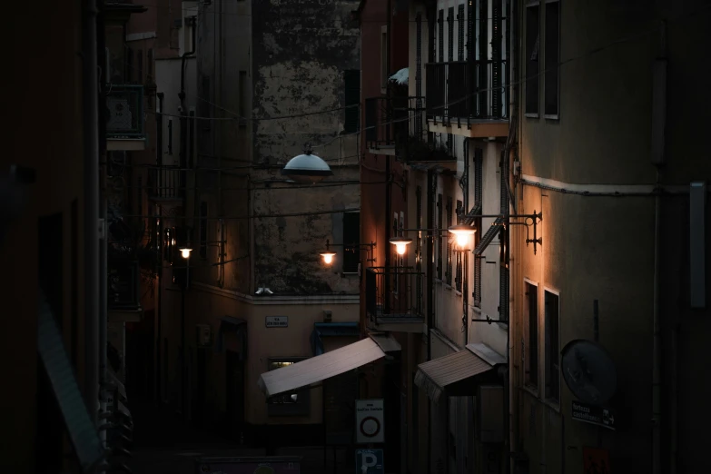 an alleyway at night with lights turned on and the building almost dark