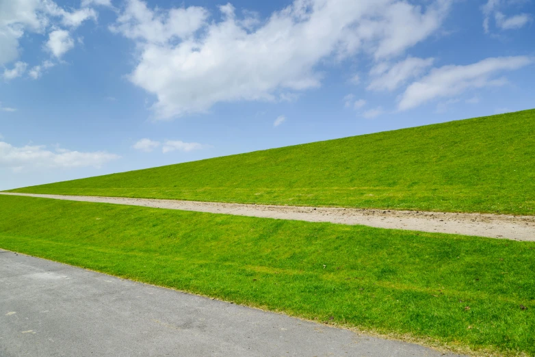 green grass and road on the side of a hill