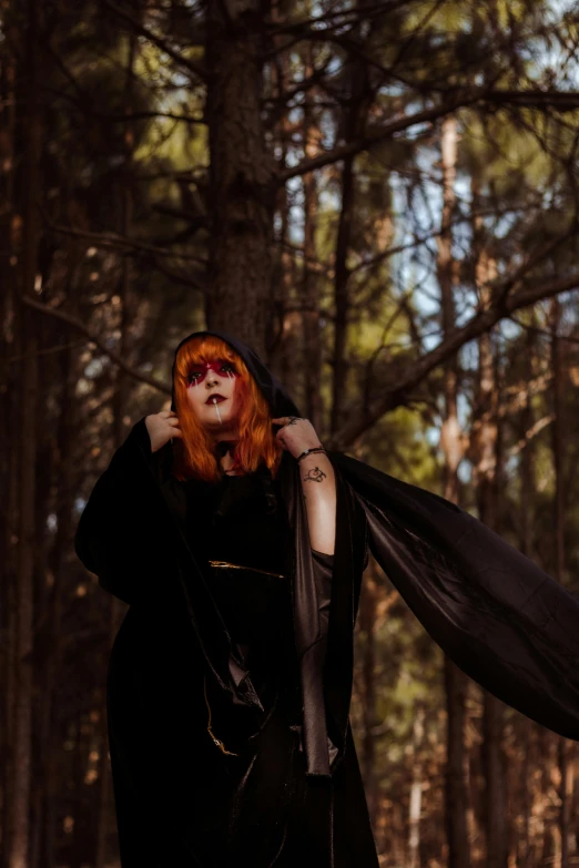 a beautiful woman with red hair in the woods