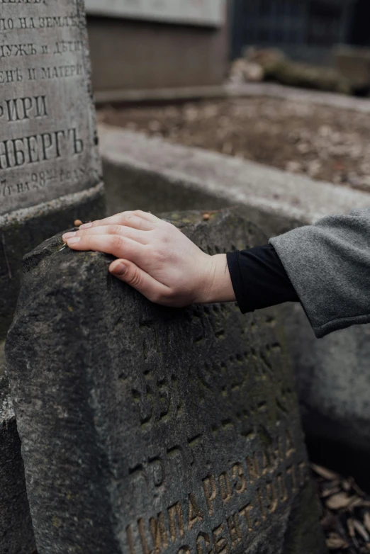 someone is touching the headstones of their graves