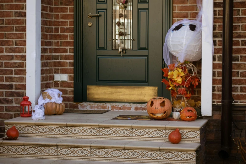 an entrance decorated with fake jack o lanterns and pumpkins