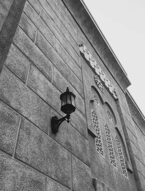 an old lamp attached to a stone wall