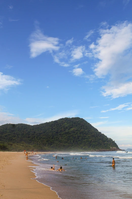 a group of people playing in the water on the beach