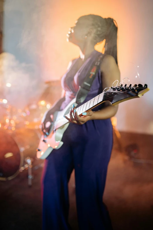 a young woman in purple plays a guitar