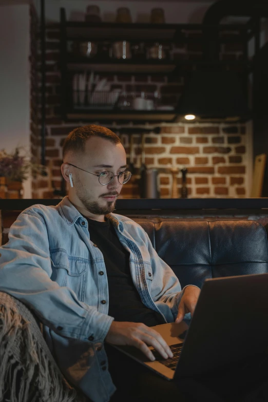 a man sitting in a leather chair looking at his laptop