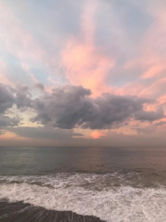 some water sand clouds and orange sky on the beach