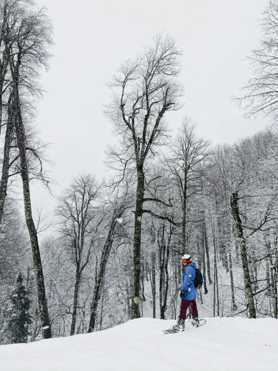 a man standing on top of a snow covered slope