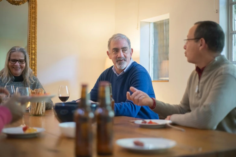 a group of people sitting around a table eating and drinking