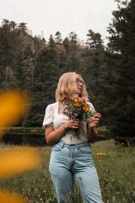 a woman in the field has sunflowers