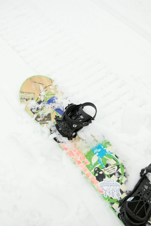 snowboard and boot laying on top of the snow