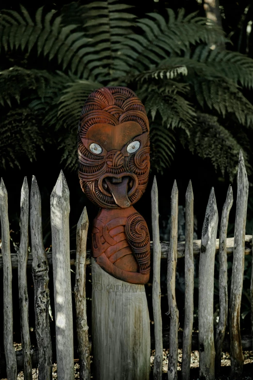 an old fashioned statue standing next to a fence