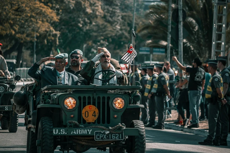 military jeep driving in front of a crowd