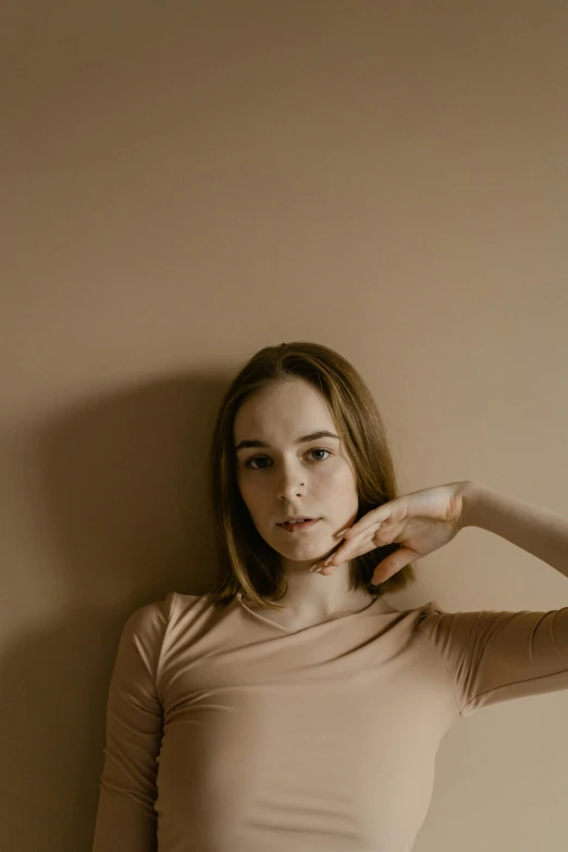 a woman leaning against the wall with her finger