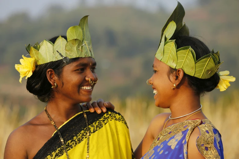 two young women smile brightly at each other