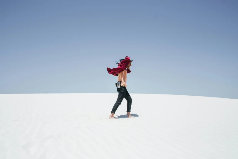 a woman in black and red is walking down a hill