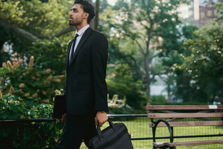 a man in suit and tie holding suitcases