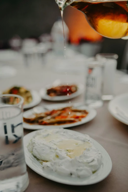 a table with plates of food and drink pouring tea on top