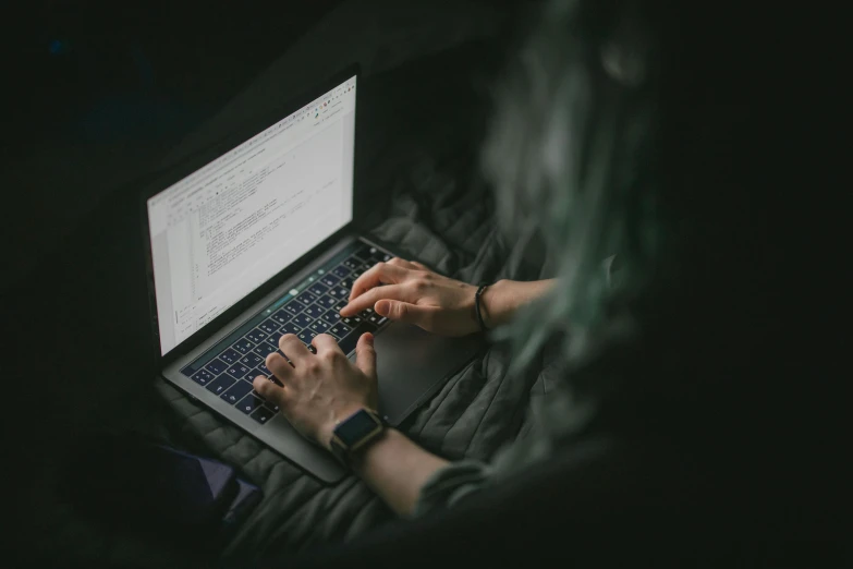 a woman in black jacket sitting on laptop computer