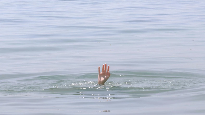 hand reaching out to someone swimming in the ocean