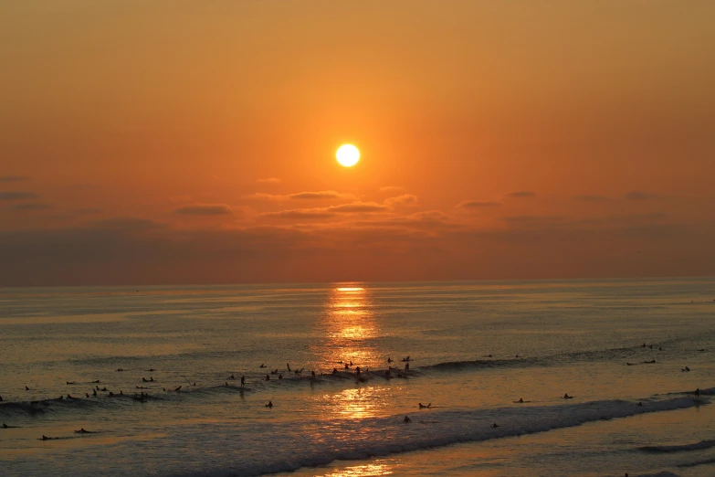 a sun setting over the ocean on a beach