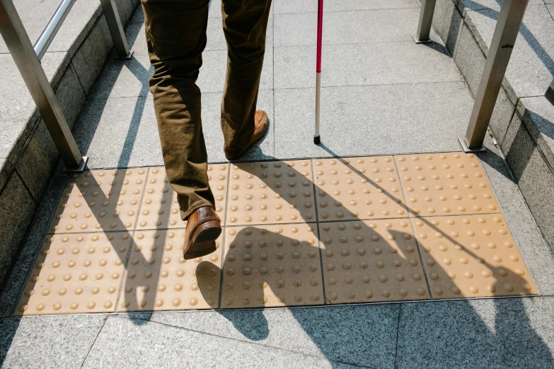 a person walking down the sidewalk using a cane