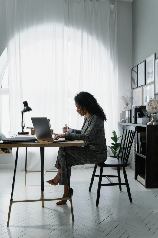 a woman using her laptop at a wooden table