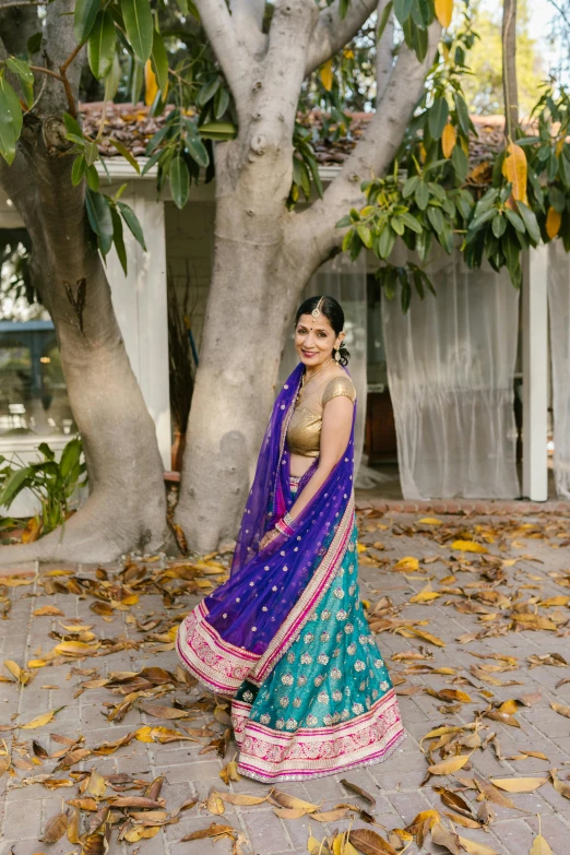 a woman in a indian wedding dress posing with her arms around her neck