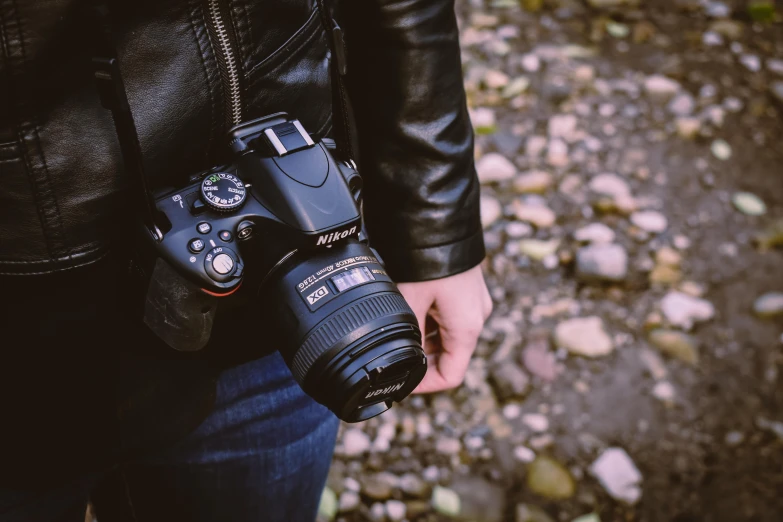 a person holding a camera near rocks