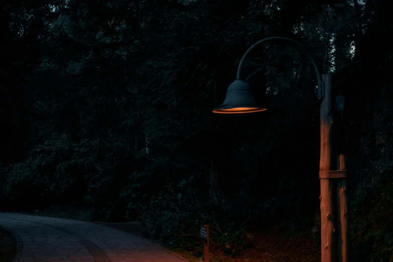 an old lamp hanging from the side of a metal pole