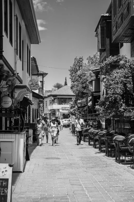 people walking down a brick road in a village