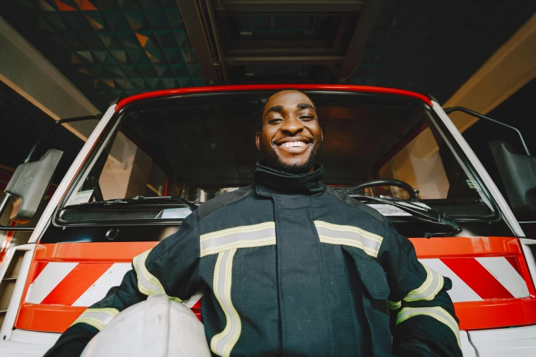 a man wearing a fire fighter's outfit standing next to a red and white fire truck