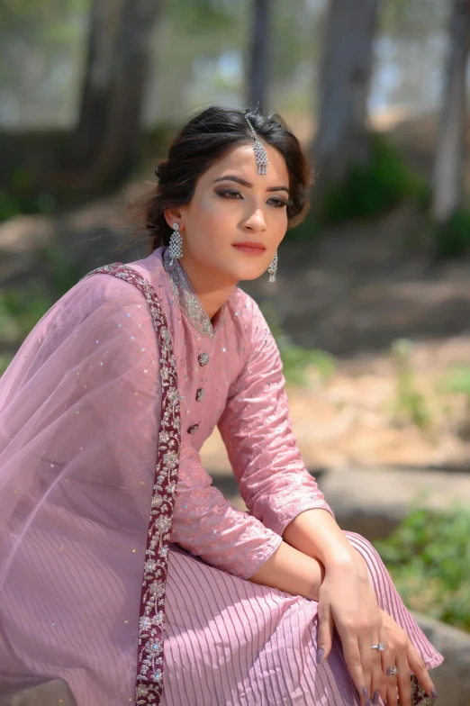 a woman sitting on top of a bench in a pink dress