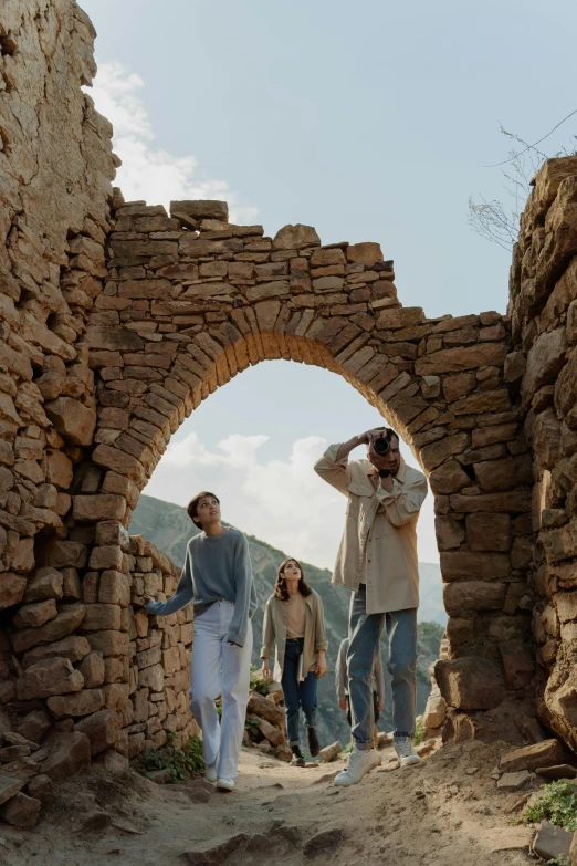 a group of people standing under a rock archway