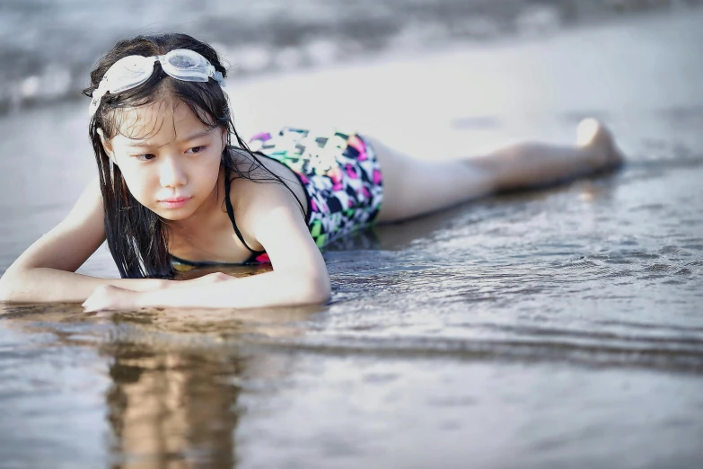 a girl laying on her belly in the water