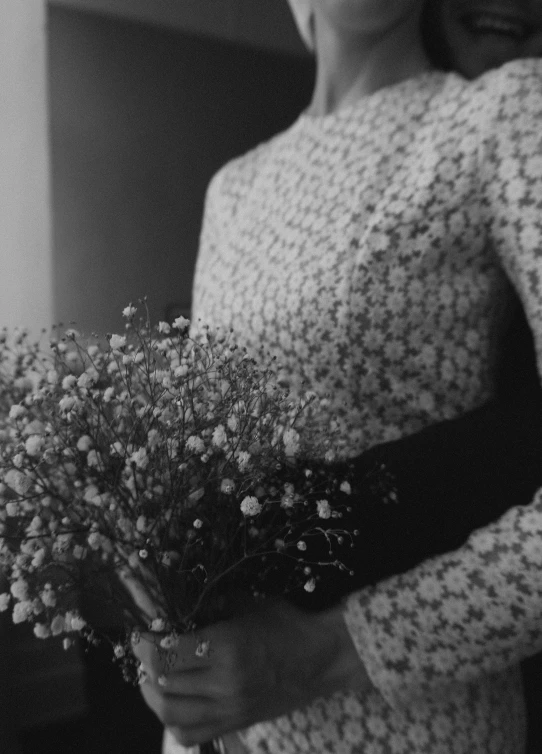 black and white po of woman with flower bouquet in front