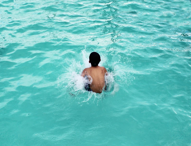 there is a man swimming in a blue lake