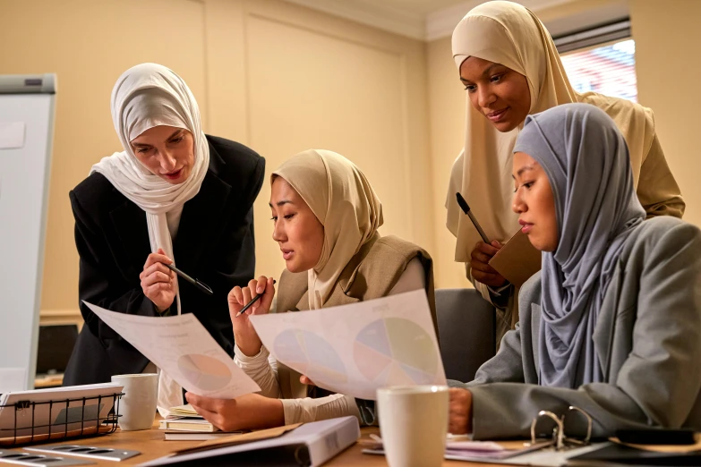 four women in headscarves are at a table