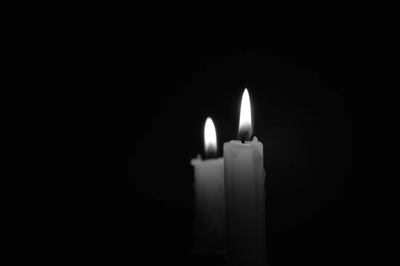 two lit candles on dark background are not white